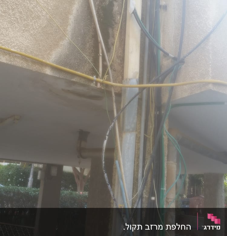 כבלים וצינורות מחוברים לקיר מתחת לגג